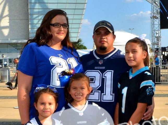 Katy and Moises Argueda with their daughters wearing Dallas Cowboys and Carolina Panthers jerseys