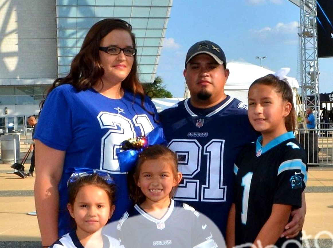 Katy and Moises Argueda with their daughters wearing Dallas Cowboys and Carolina Panthers jerseys
