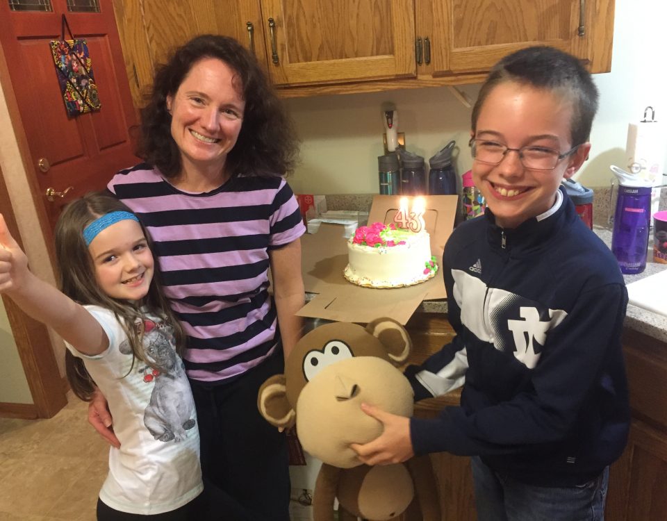 Jennifer and her kids celebrating her 43rd birthday with cake and a stuffed monkey