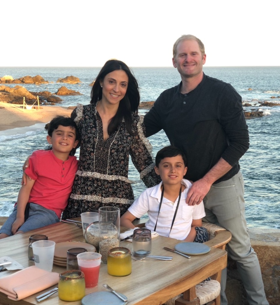 Jenine D with her husband and sons about to eat dinner by the water