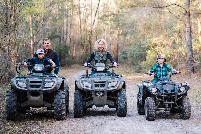 Jenny Edwards 4 wheeling through the woods with her husband and sons