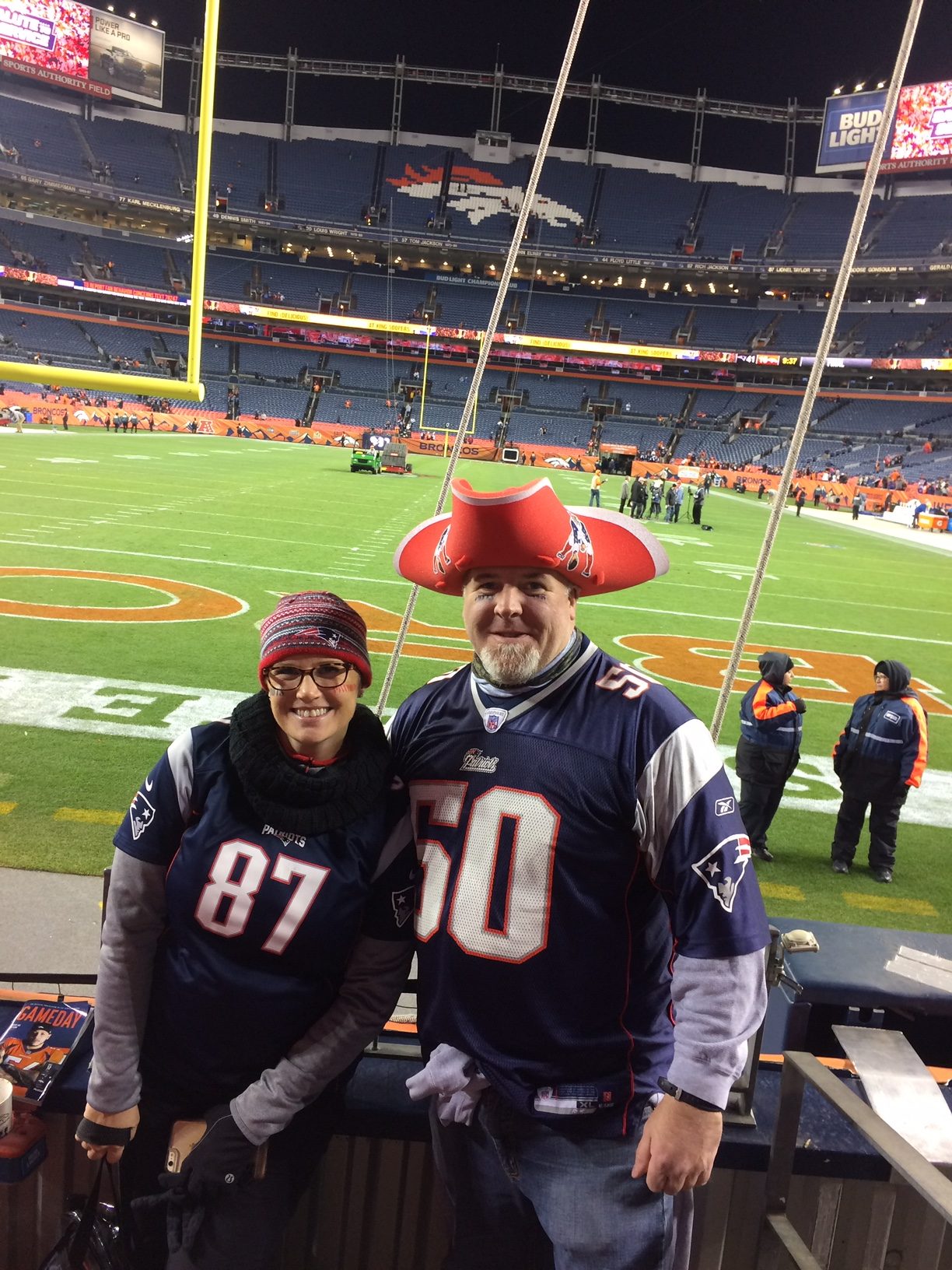 Erica Hendry and husband at Mile High Stadium wearing Patriots jerseys and gear
