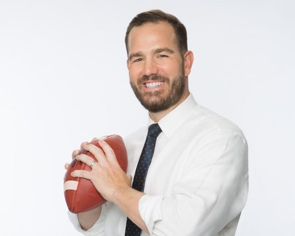 Sports podcasting legend Ross Tucker holding a football like a quarterback