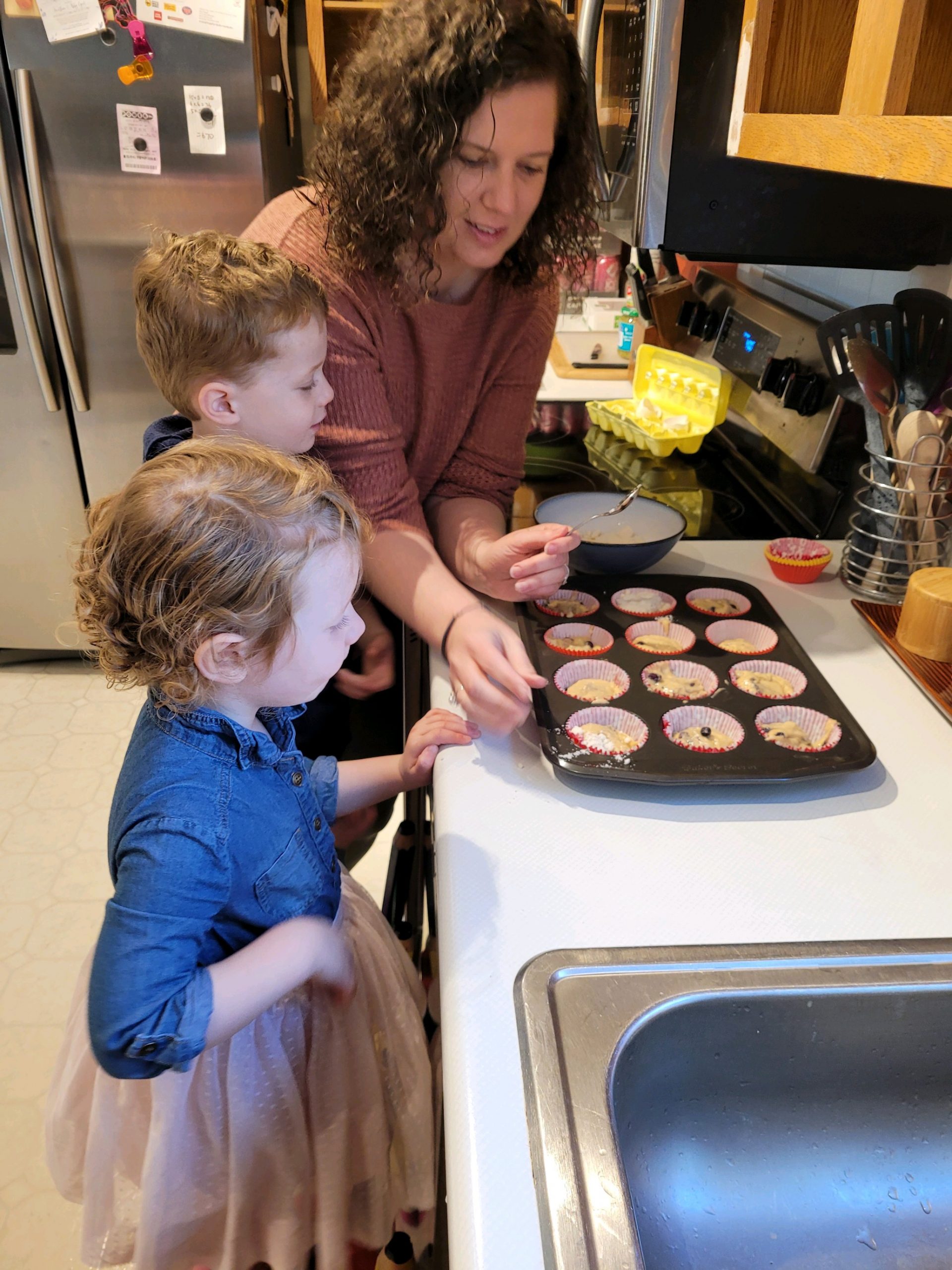 denise baking cookies in muffin tins with her son and daughter