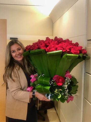 Trisha Webber holding a humongous bouquet of red roses
