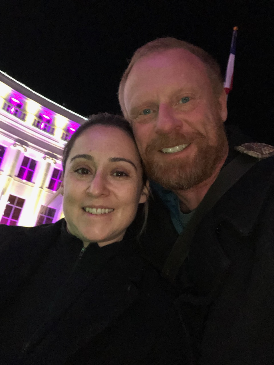 Angie and Kevin Hento in front of a White House with purple lights