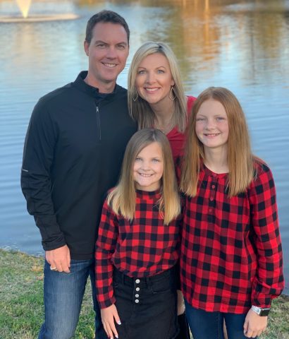 Jodi Wardinsky with her husband and daughters who are wearing matching checkered flannels