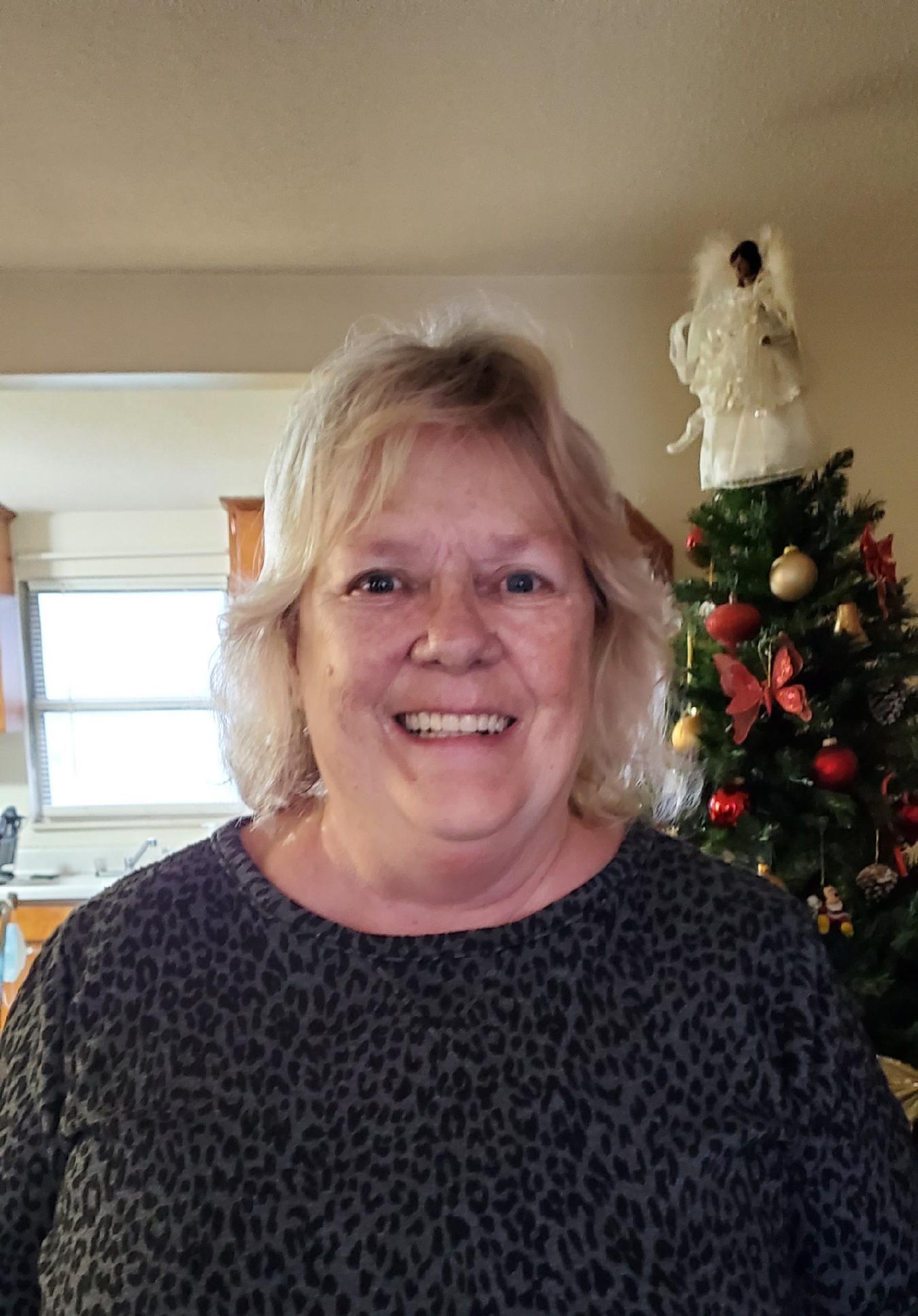helen yarbrough smiling wide in front of the christmas tree