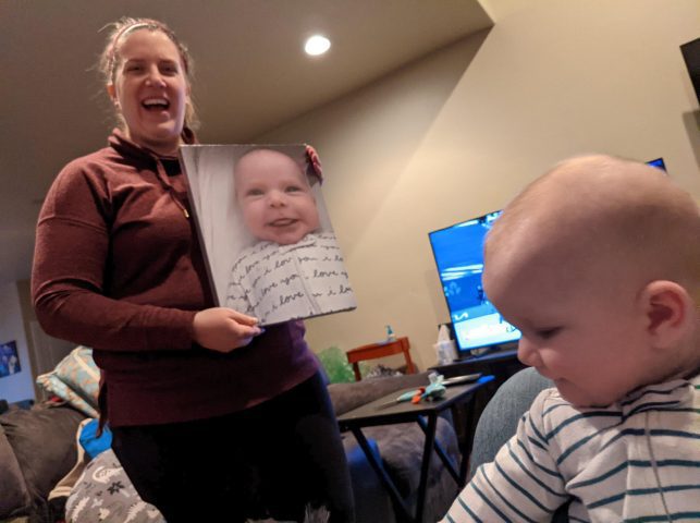 Kelsey Dallas showing her baby boy a portrait of him sticking out his tongue