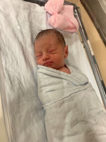 Avery Mila Rinaldo Sax newborn coddled in her hospital bed