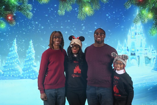 Diyell Holmes' with her family in front of a Christmas-themed green screen