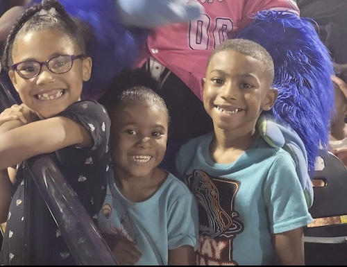 The Wright children smiling at a sporting event