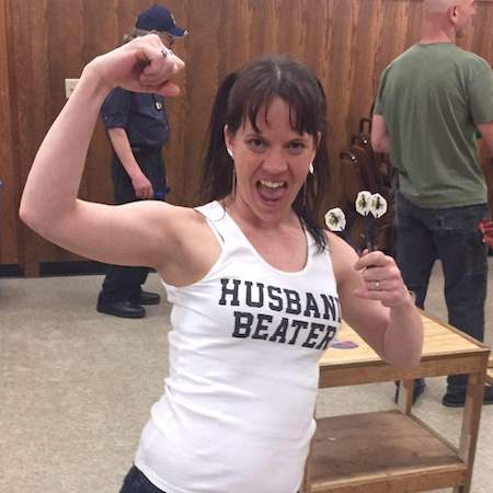 Bethany Fincher wearing a husband beater tank top while holding darts