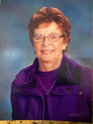 Dorothy Price smiling in her purple getup