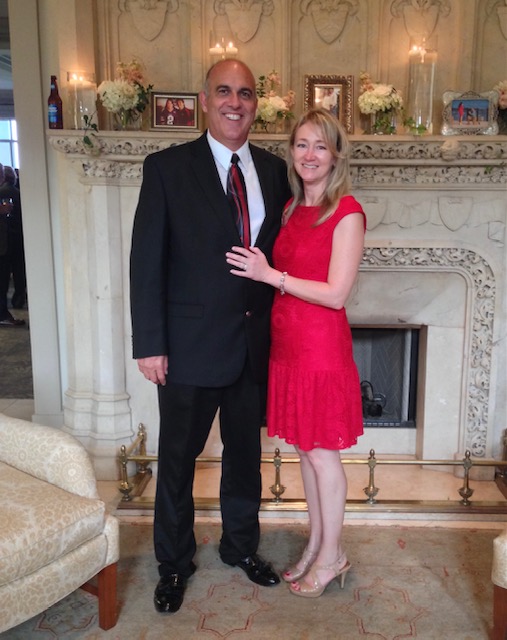 Tami and Michael Have smiling in front of the fireplace all dressed up