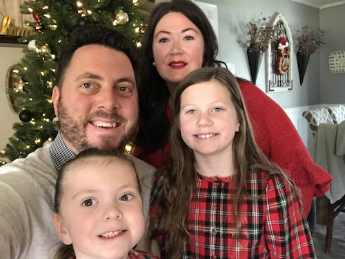 Kate McKillop with her husband and children in front of the Christmas tree