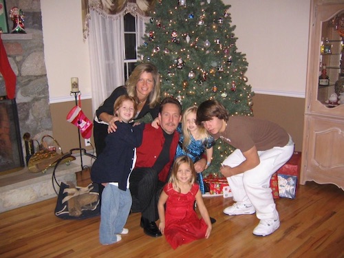 Jackie Howe with her husband and children gathered around the Christmas tree