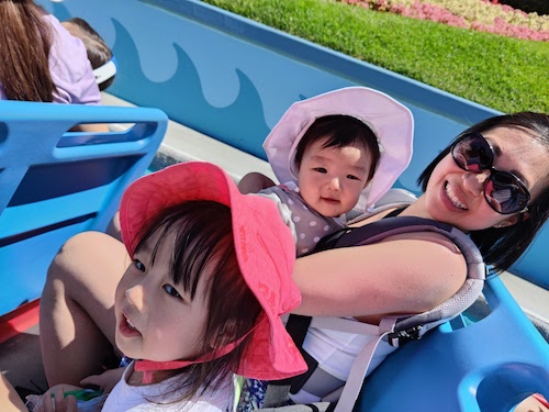 Rosanna Oh with her kids sitting on a ride with them all looking happy