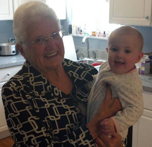 Pat Egan holding grandchild in the kitchen