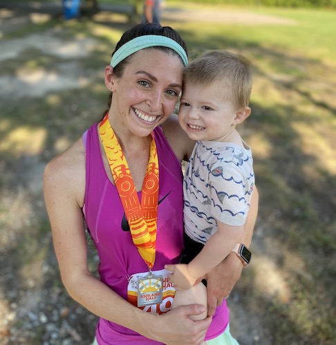 Evan Wash holding her son after finishing running a race
