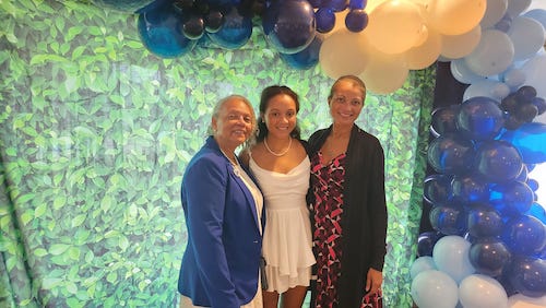 Lygia with some family members celebrating with blue and white balloons