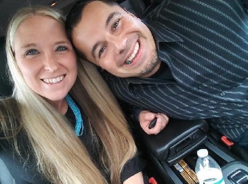 Adina and Michael Cavallini taking a smiling selfie in the car