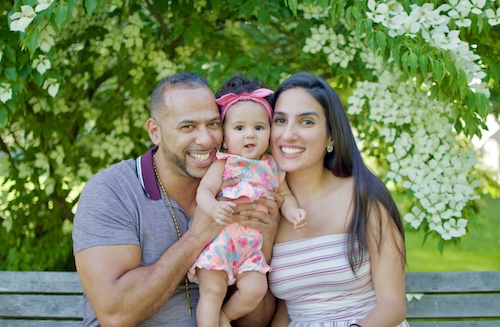MaFe with her husband Nick and daughter Demi sitting on a bench with a tree in the background