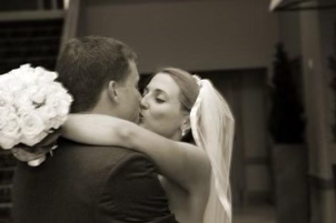 Tara and Jason Busby kissing on their wedding day (sepia hue)