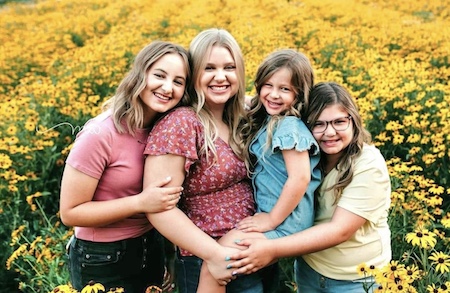Willow Curtis and her sisters hanging out in a Sunflower field