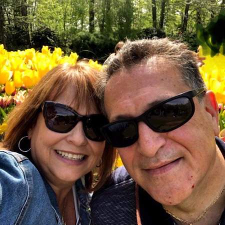 Vince Marino and his wife, Sue, in front of yellow roses
