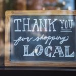 a chalkboard sign that says, "thank you for shopping local"