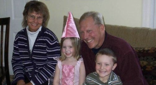 Michael L Bundy smiling with his wife and grandchildren