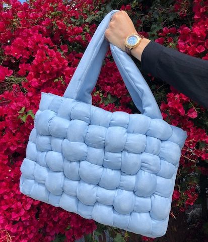 custom baby blue crochet bag held in front of a red leaf tree