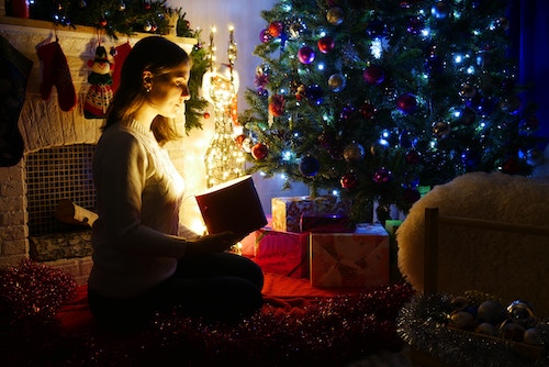 woman looking at a special gift in the darkness during Christmastime