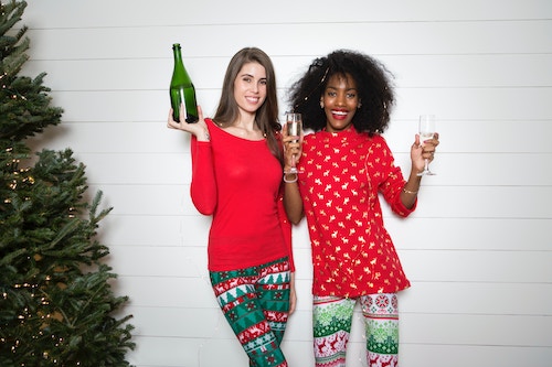 friends celebrating Christmas in matching clothes and drinking