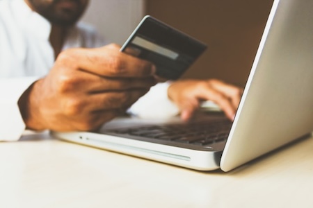 Person holding a credit card and shopping online.