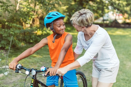 teaching a kid how to ride a bike in a forest