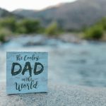 The Coolest Dad In The World sign by the water - Father’s Day gifts he’ll actually use blog post